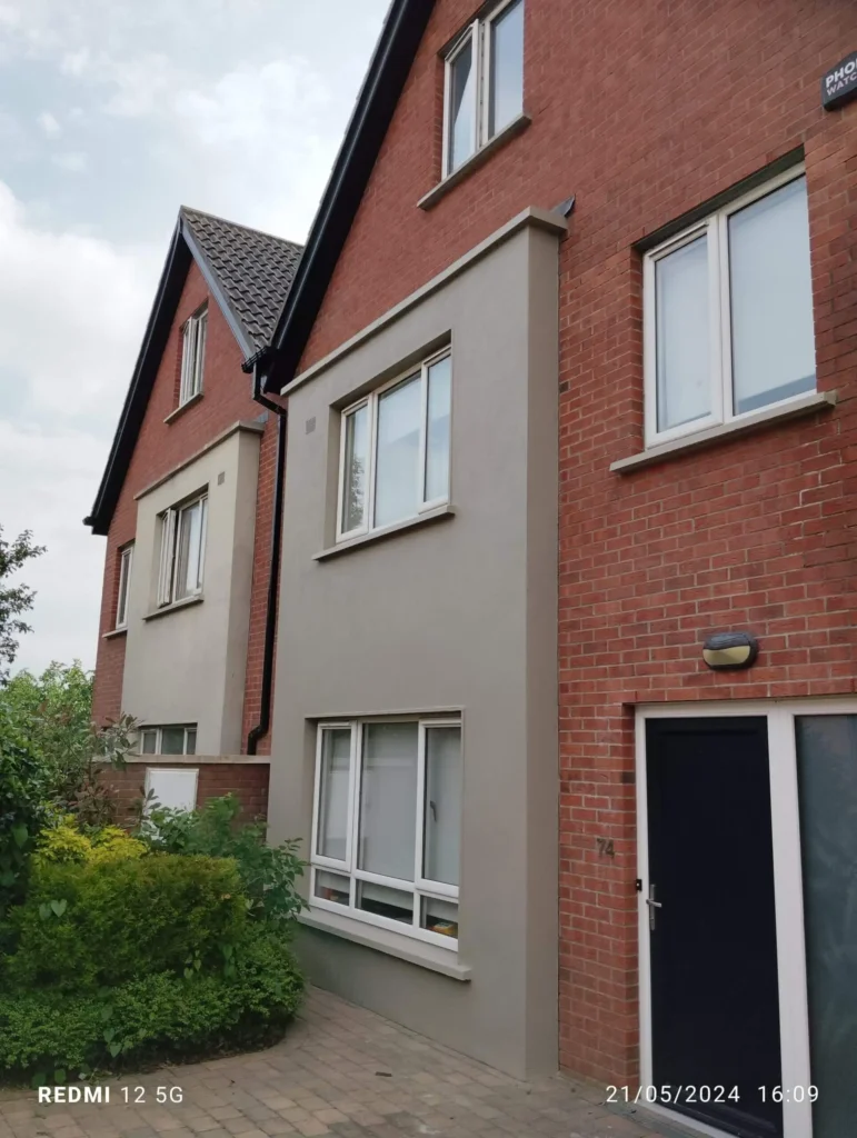 Exterior view of a brick house with grey rendered sections, showcasing handyman services in Dublin.