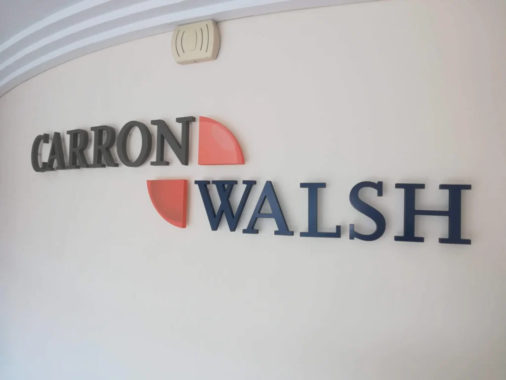 Carron and Walsh logo on a white wall, possibly representing a business in Dublin.
