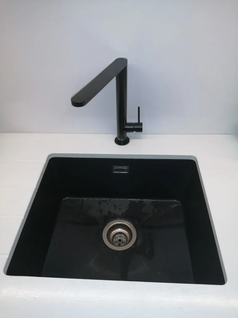 Modern black kitchen sink and faucet against a white countertop, reflecting handyman Dublin services.